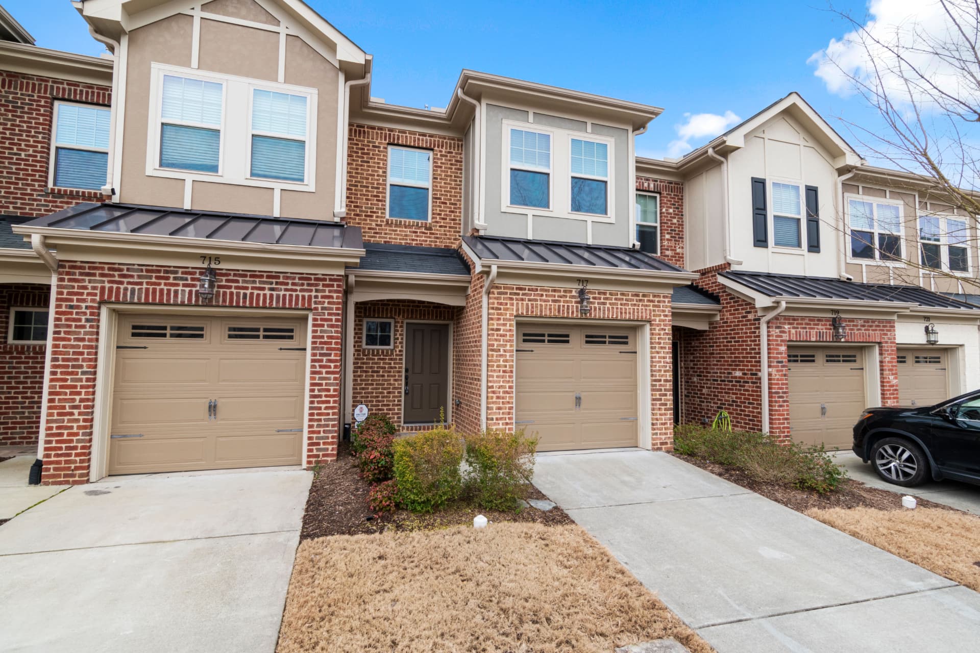Garage doors along a row of brick townhomes