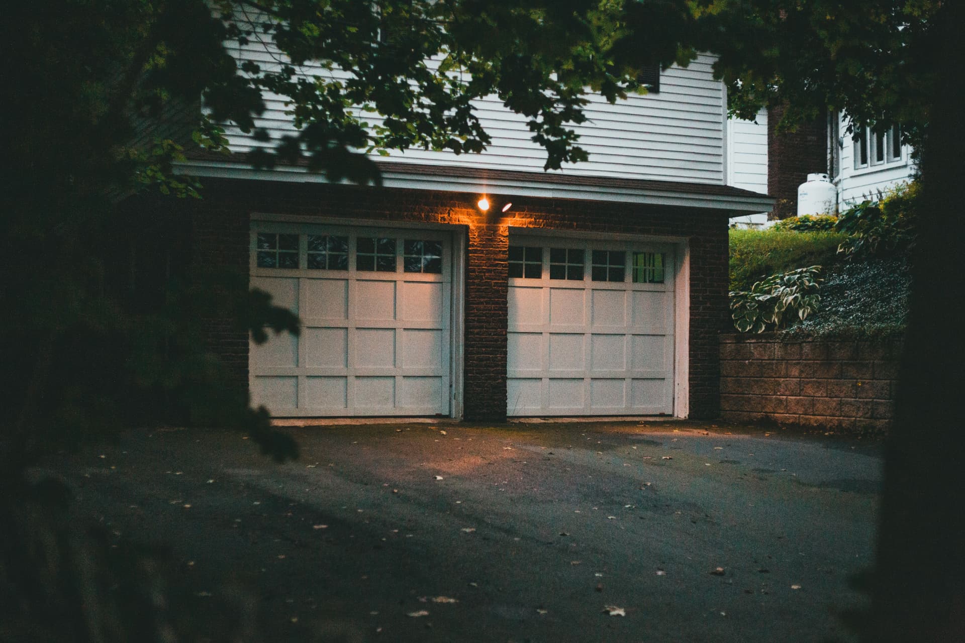 Residential garage doors lit at dusk